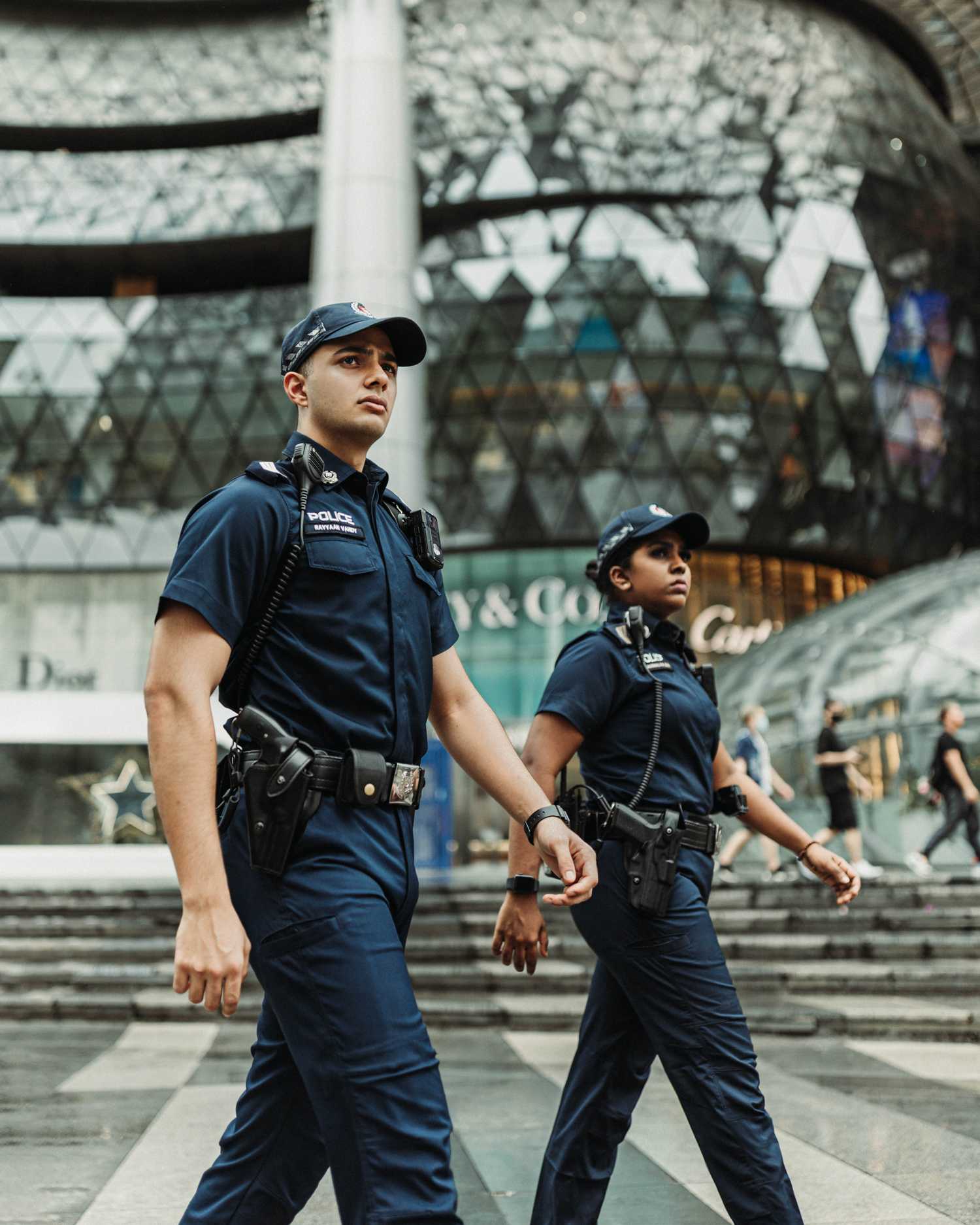 Photo of two Ground Response Force officers walking in Orchard Road, with ION Orchard building in background
