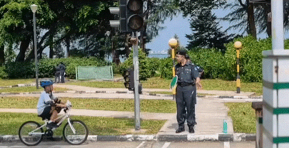A moving image of a student cycling at the Road Safety Community Park with one NPCC student holding up a sign.