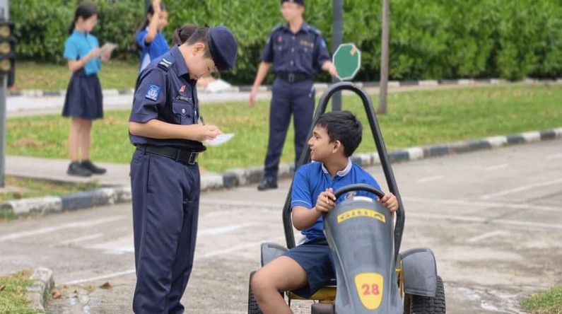A NPCC Cadet Marshall evaluates a Go-Kart driver’s road safety habits during a simulated traffic game.