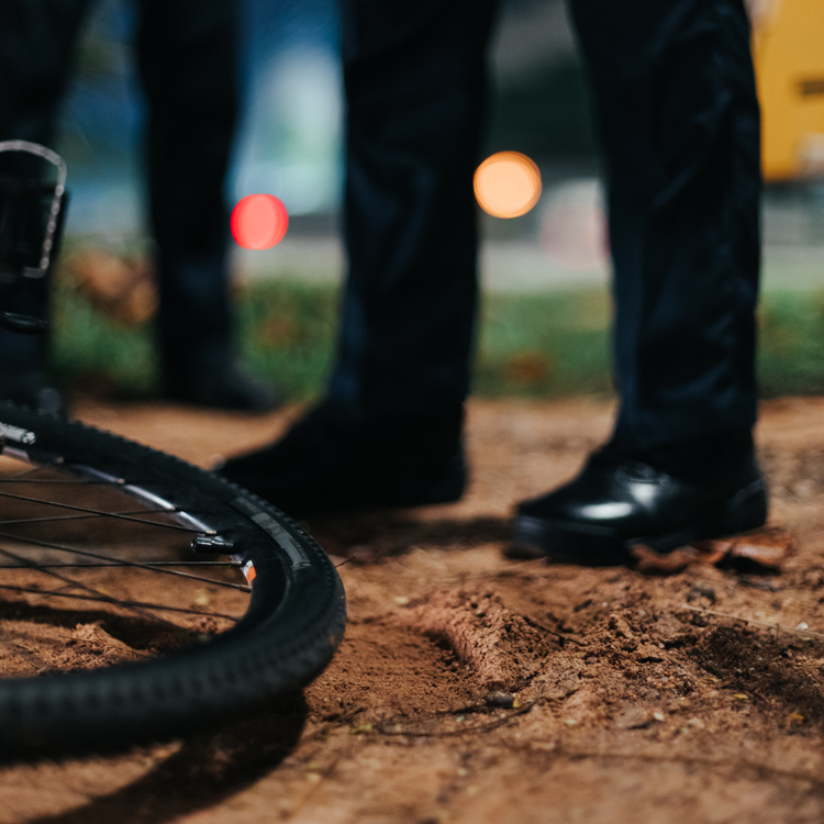 police officer standing beside bicycle toppled over on the ground