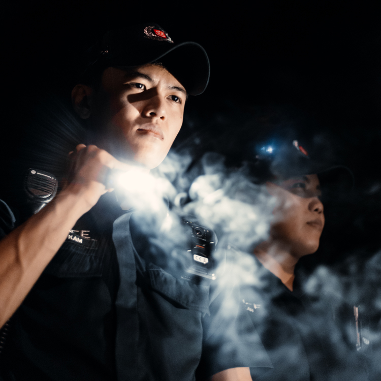 police officer shining torchlight into smoke 