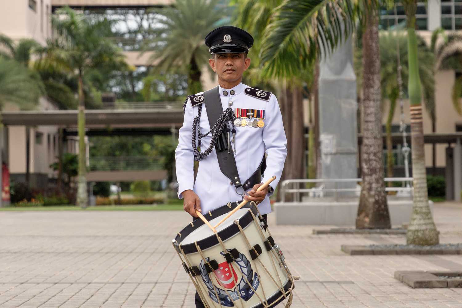 Senior Inspector Julaimi looking straight ahead and posing with his SPF Band drum. He is donning the SPF Band ceremonial uniform.