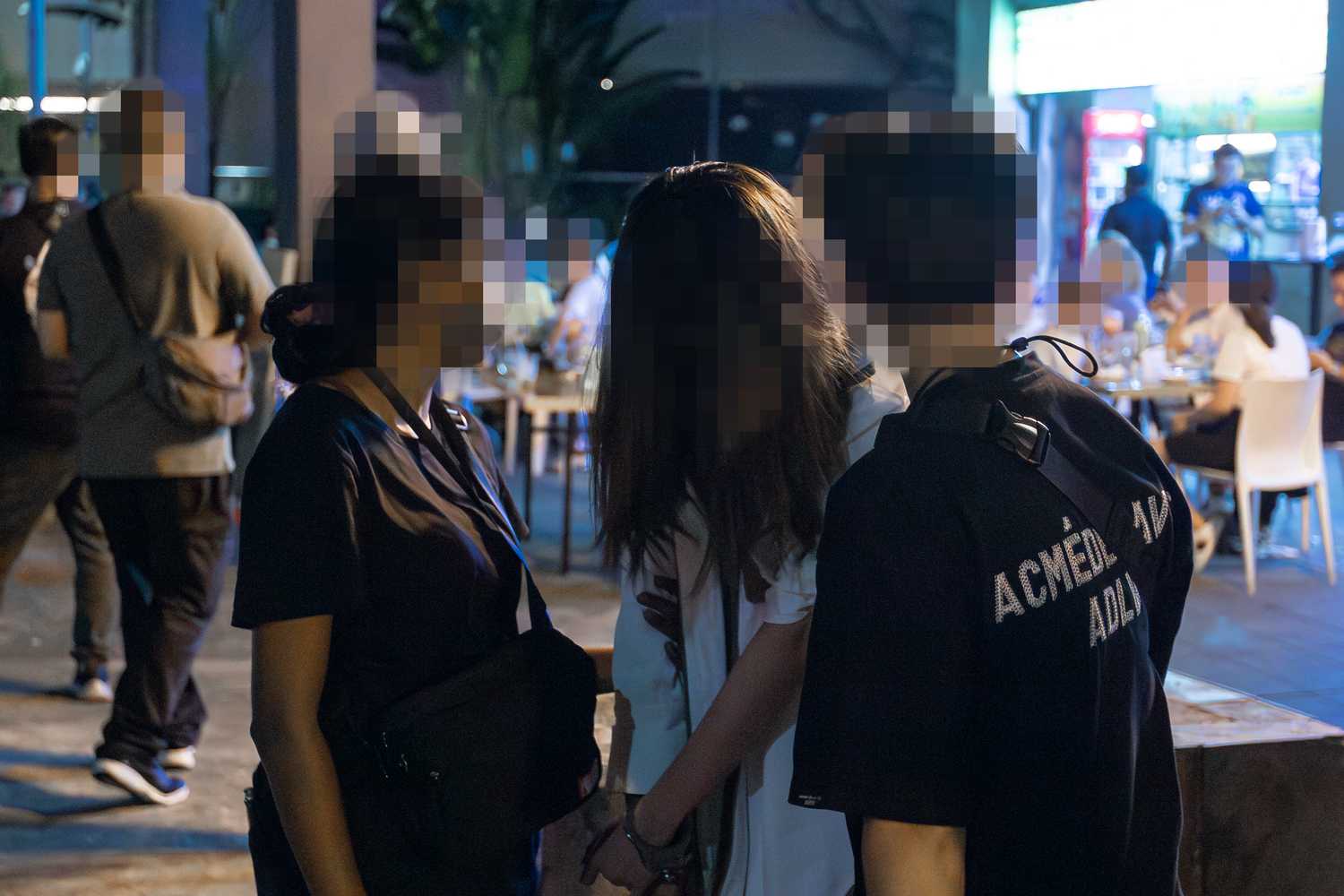 Police officers escorting a female subject who contravened employment-related offences. PHOTO: Soh Ying Jie