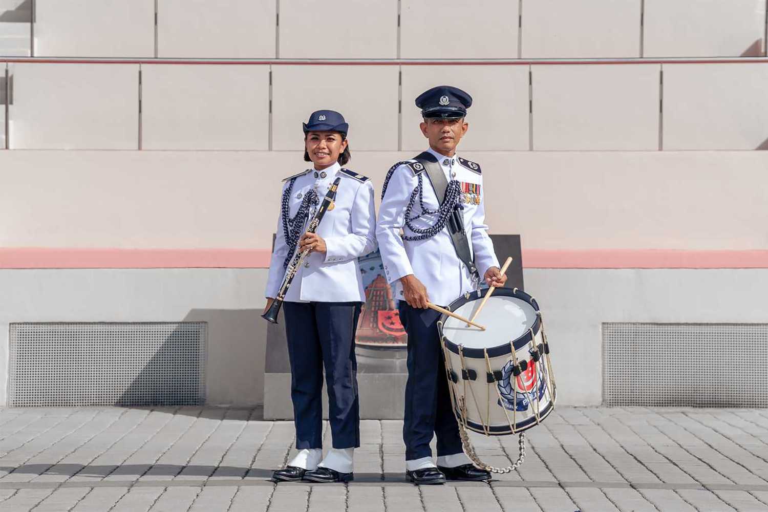 photo of two SPF band members, in ceremonial attire, with music instruments 