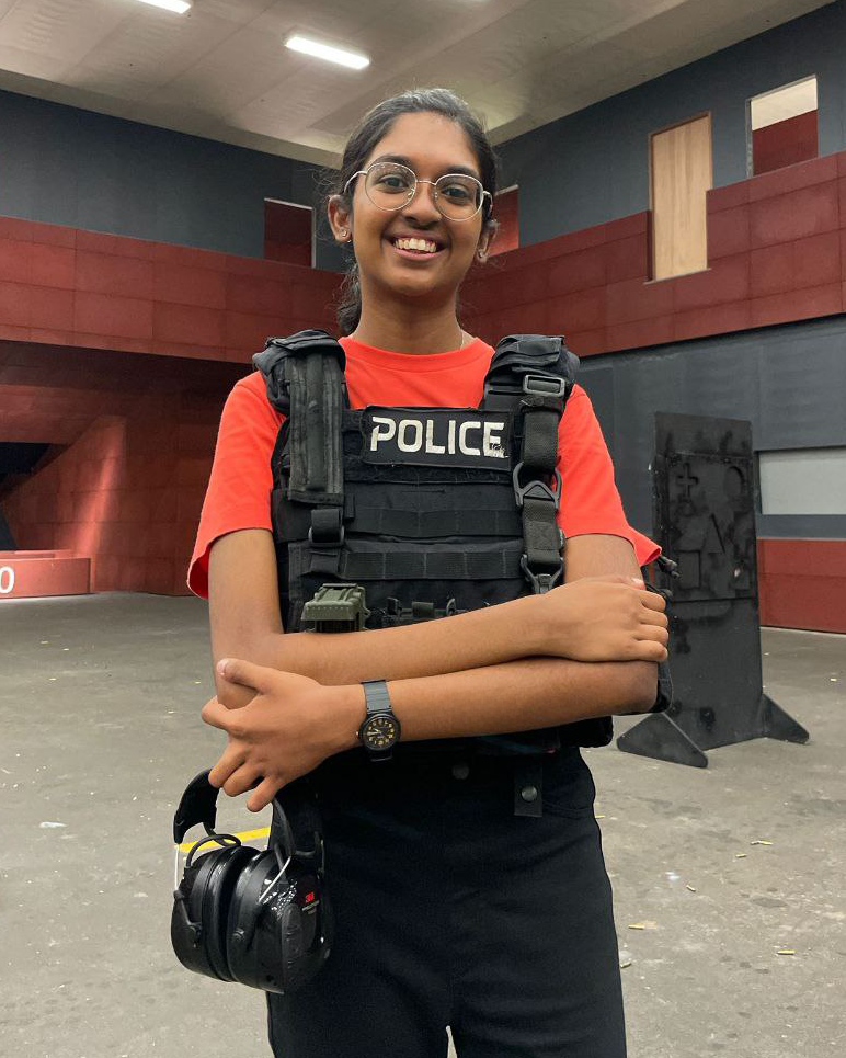 officer ashwini, wearing an orange top but wearing an SPF police vest