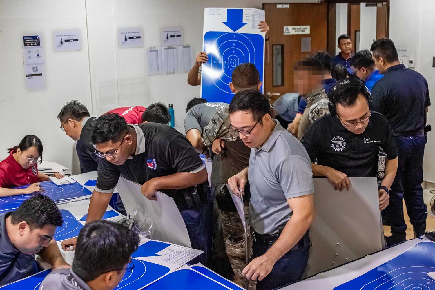 officers collecting their score charts to see where the bullets have landed