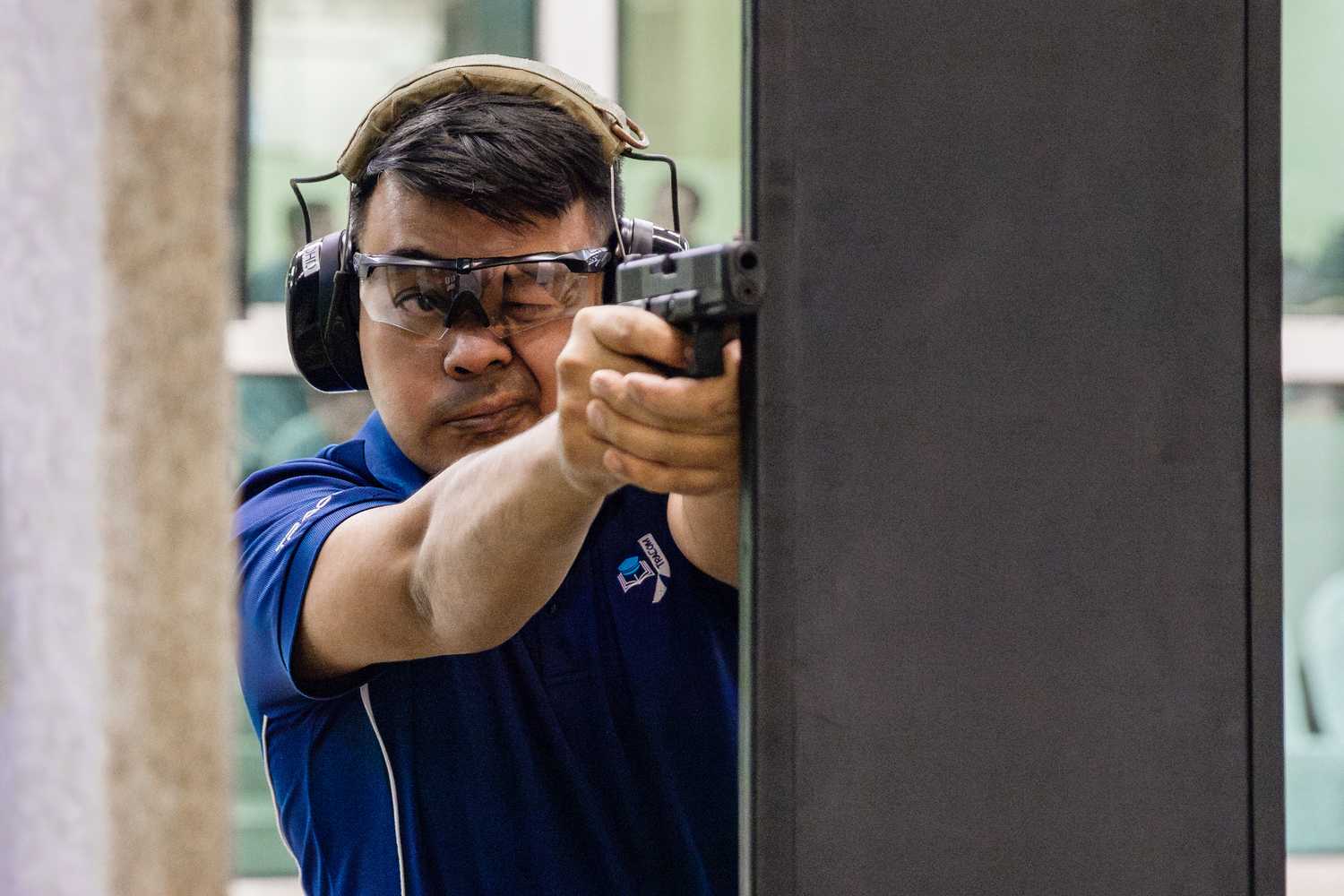officer firing gun with one eye closed, focusing on the iron sight