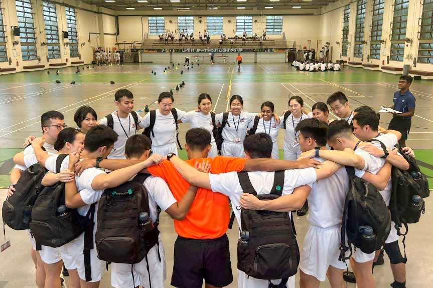 A squad photo during ASP Ang and ASP Chua's training days. They are taking part in a squad huddle.