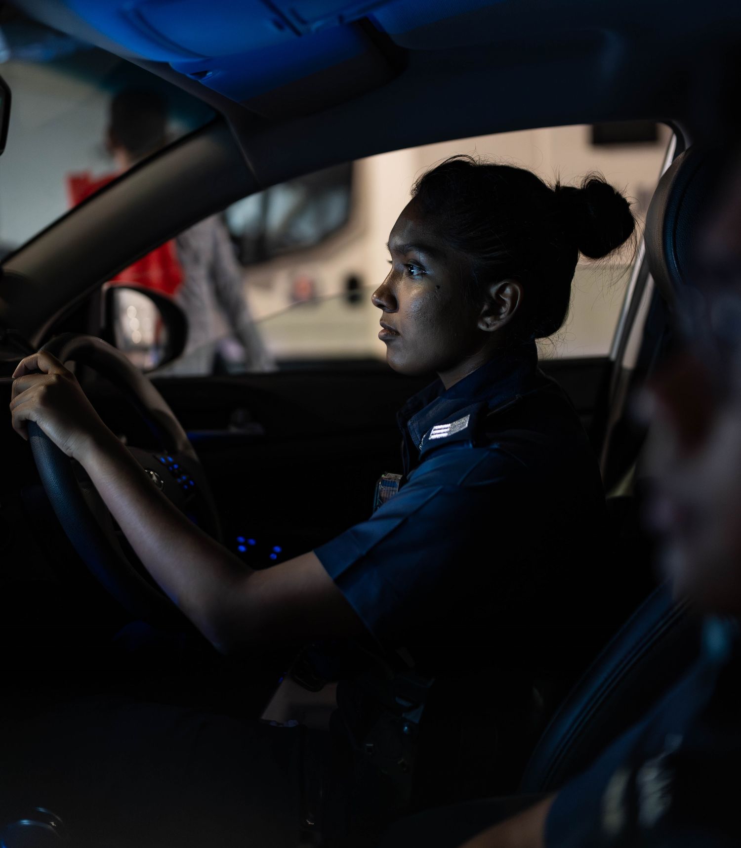 officer sitting in the police car, hands on steering wheel, ready to drive