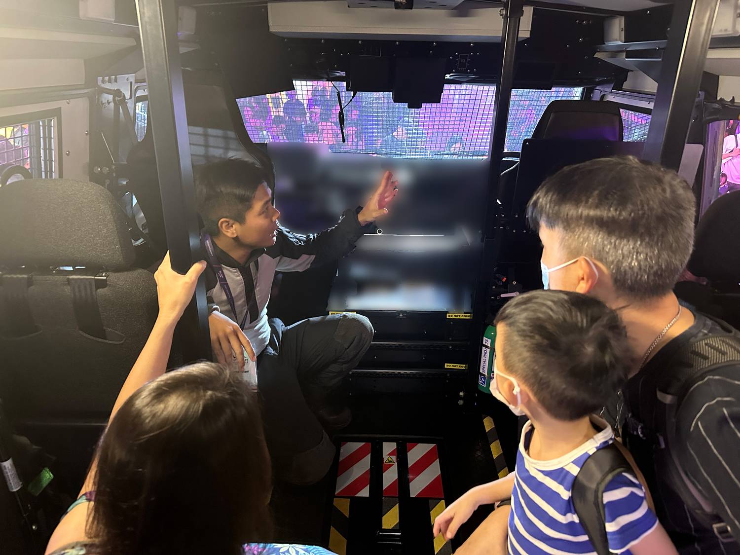 an officer inside the tactical strike vehicle explaining to members of the public about the vehicle