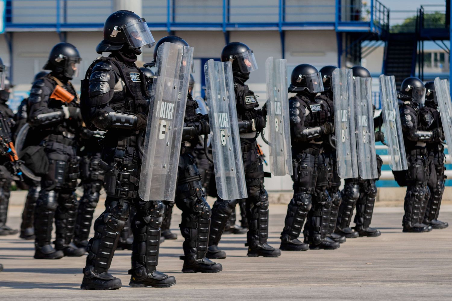 fully geared SOC troopers wearing all black and carrying riot shields