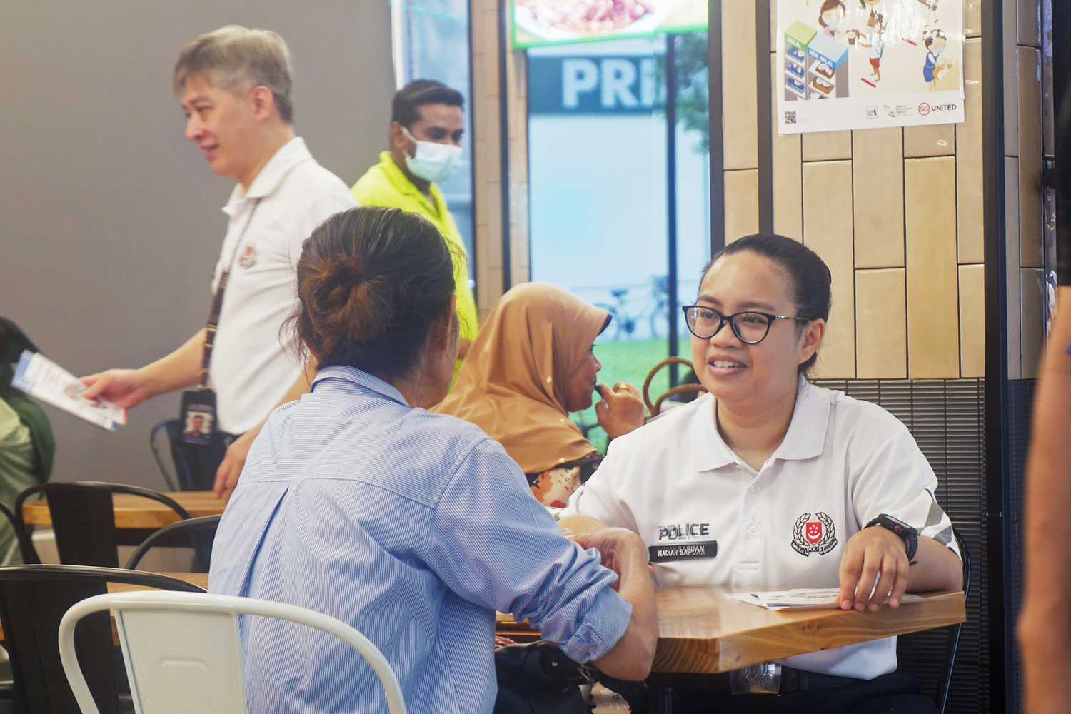 An officer having a conversation that she enjoys during the Coffee with a Cop session.