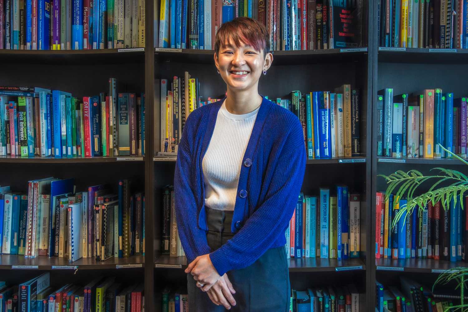 Ms Khoo Yan Leen, a Police Psychologist and the Assistant Director of the Organisational and Personnel Psychology Division, stands proudly in front of the camera and smiling.