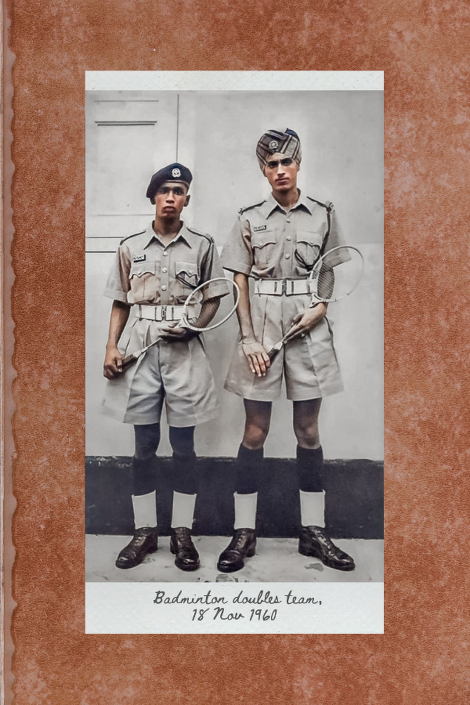 a sikh officer on the right standing with his colleague who is on the left, holding badminton rackets