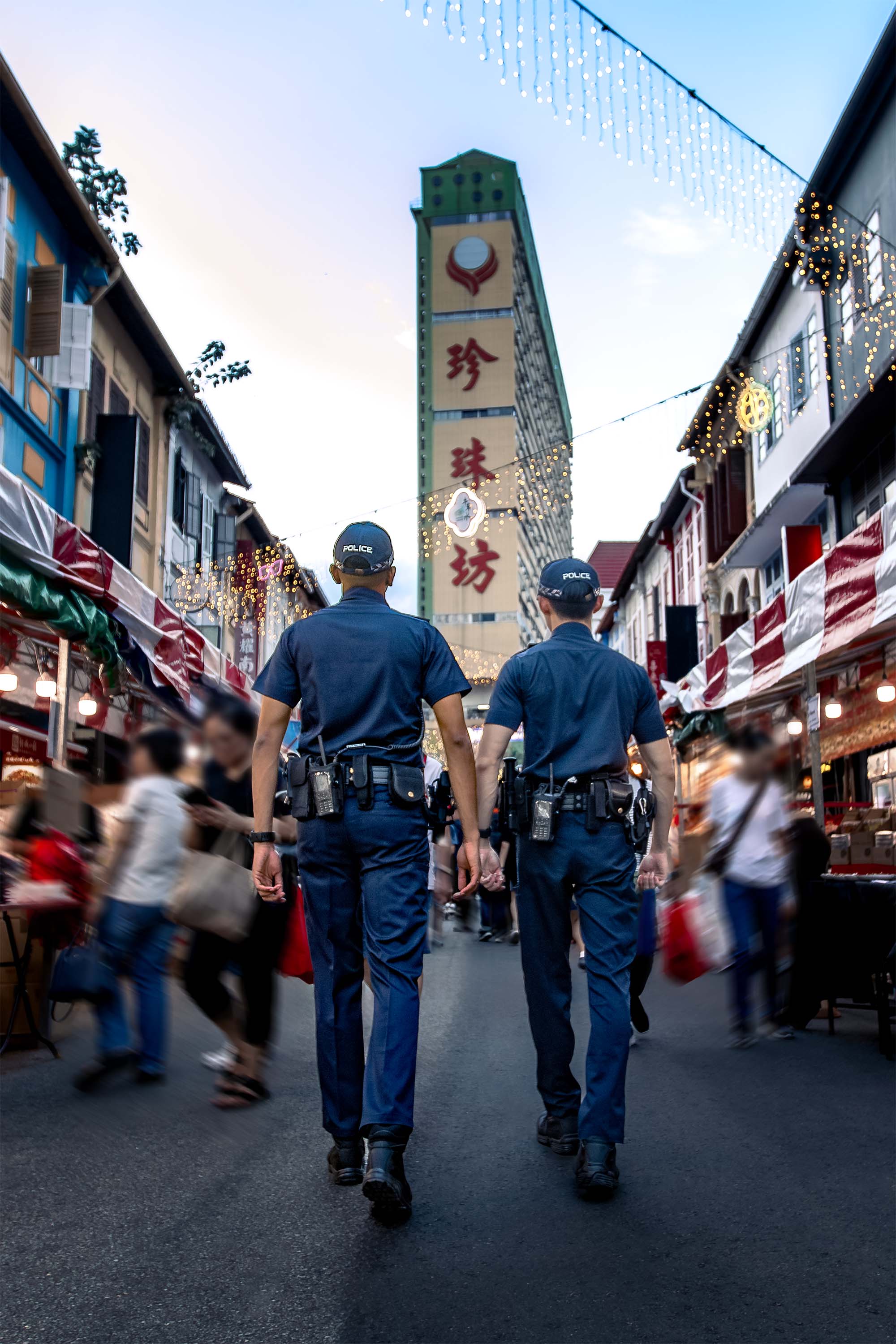 two officers walking towards the 12o'clock direction. Behind them is a tall building