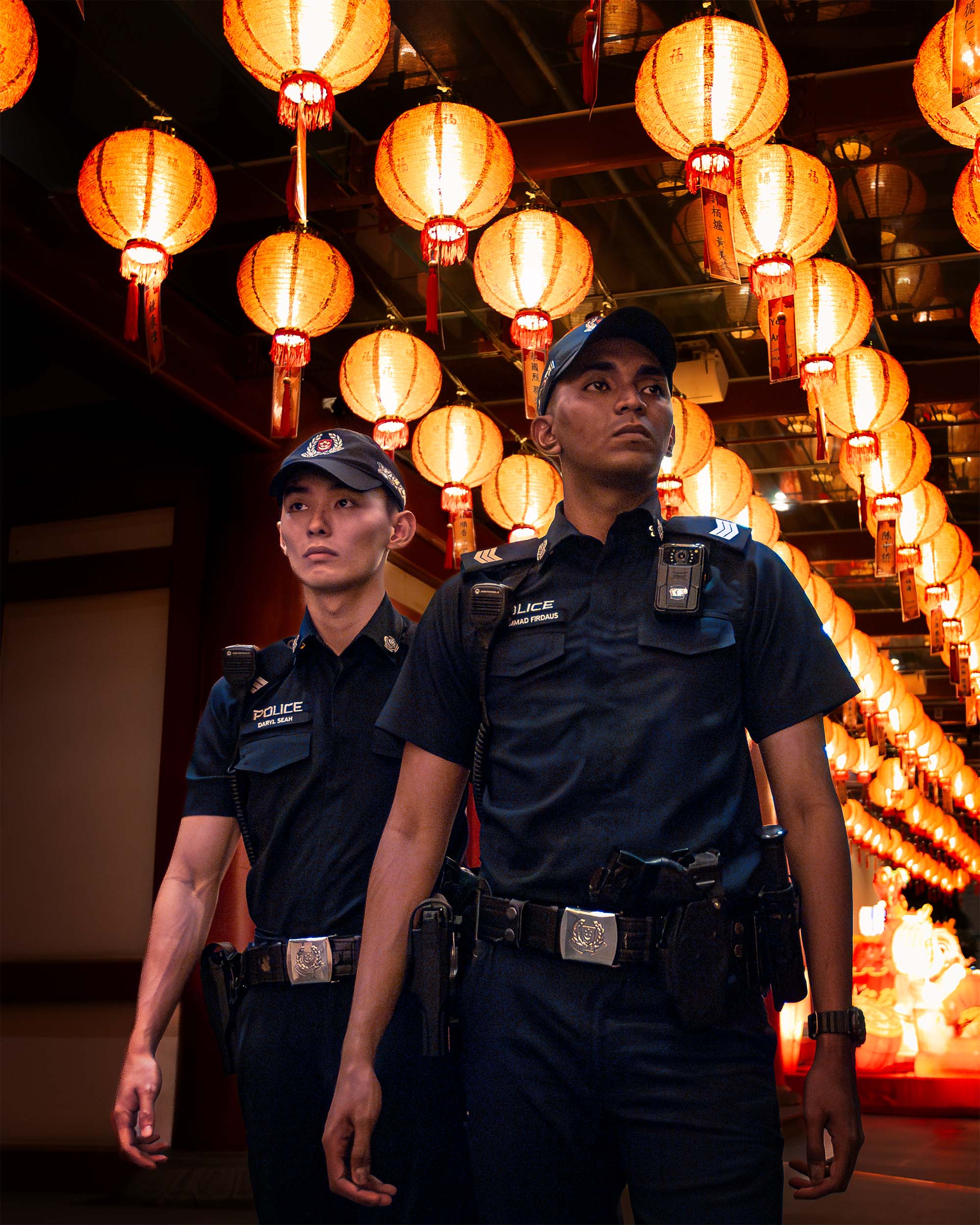 officers patrolling beside the buddha tooth relic temple, with a lot of chinese lanterns hanging above their heads