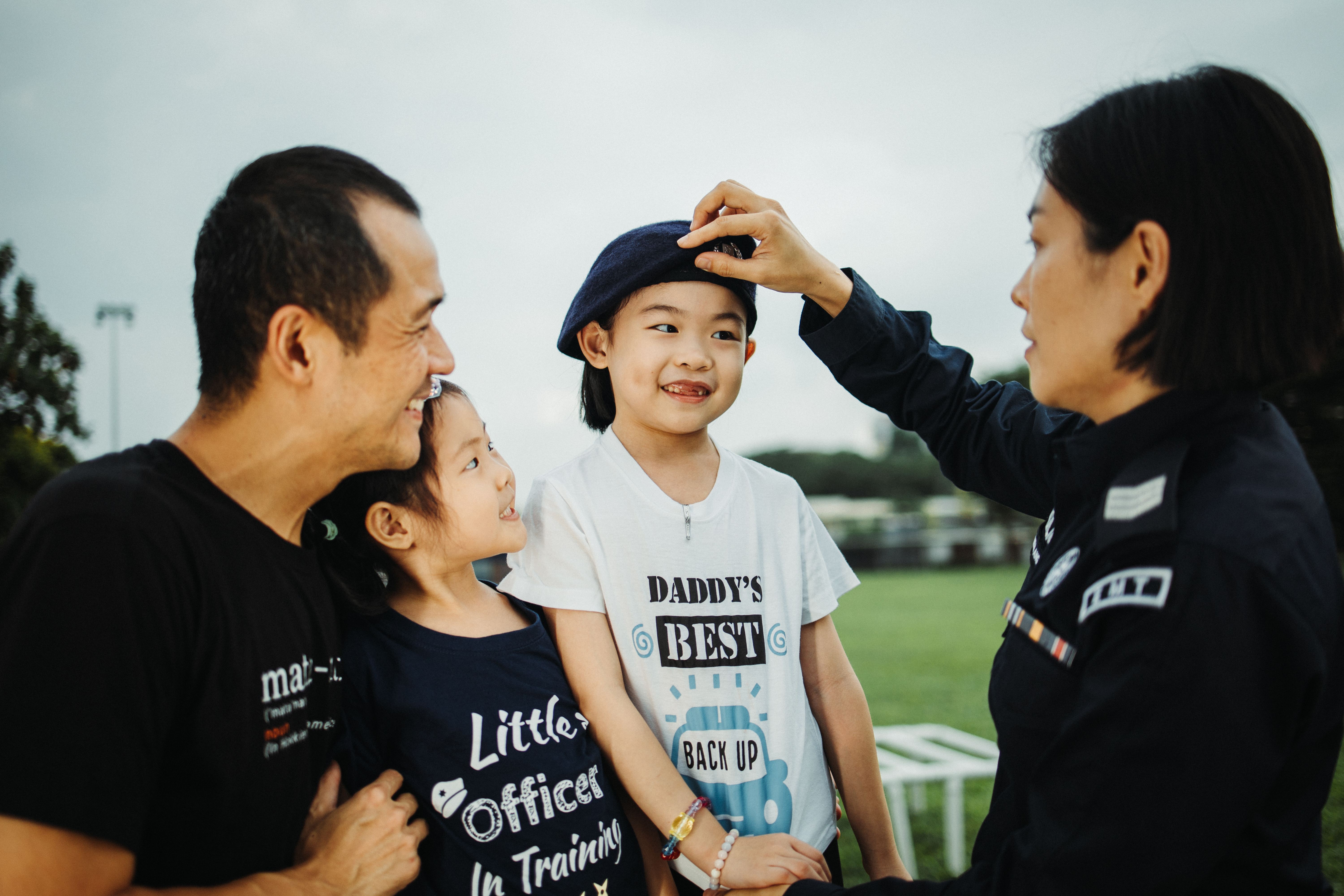 mother donning the beret for daughter together with father and youngest daughter