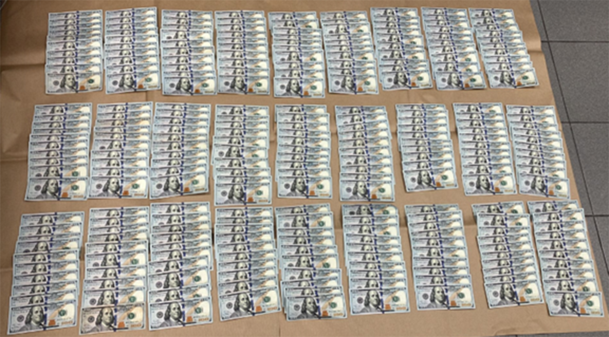 US$74,600 in US$100 denominations were recovered from the two men and seized as case exhibits.