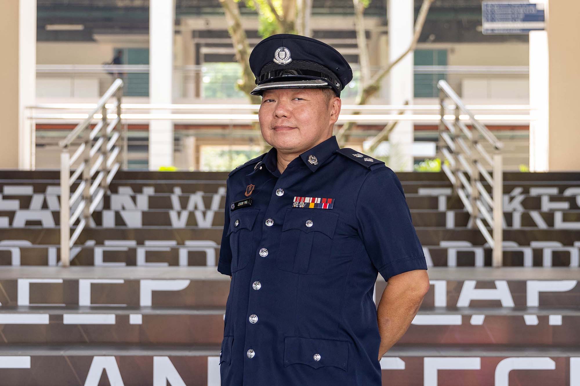 photo of police officer posing infront of camera and standing infront of a flight of stairs