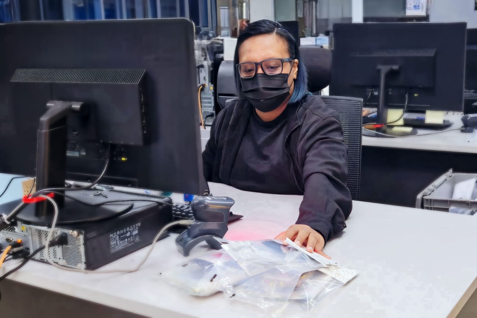 a personnel bagging some items into a small labelled plastic bag