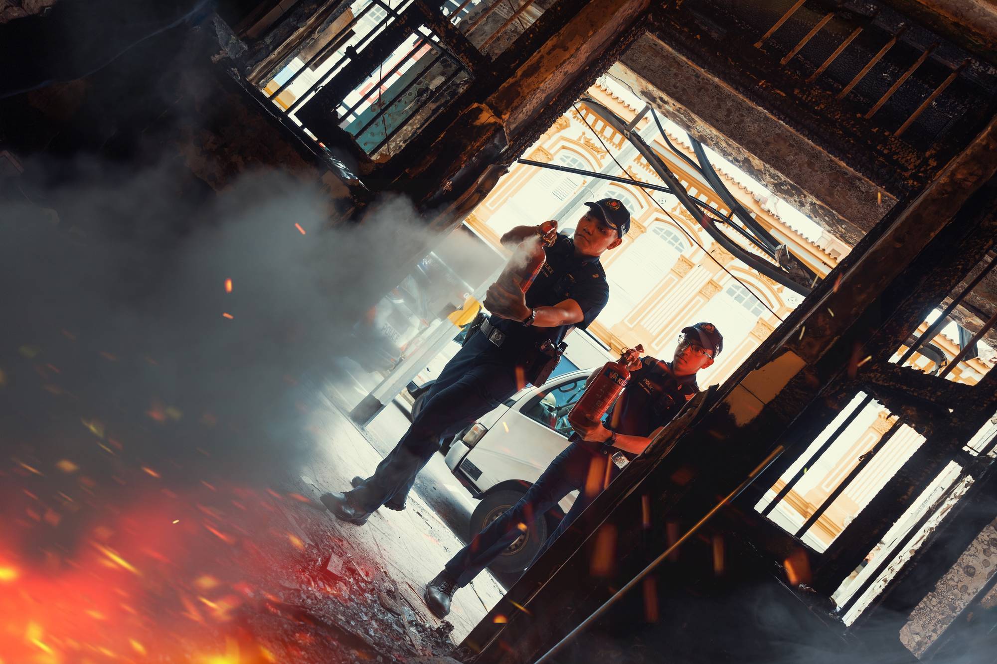 the unit has visible fire and the shot is from inside the unit. Officers are standing outside and spraying their fire extinguish at the fire