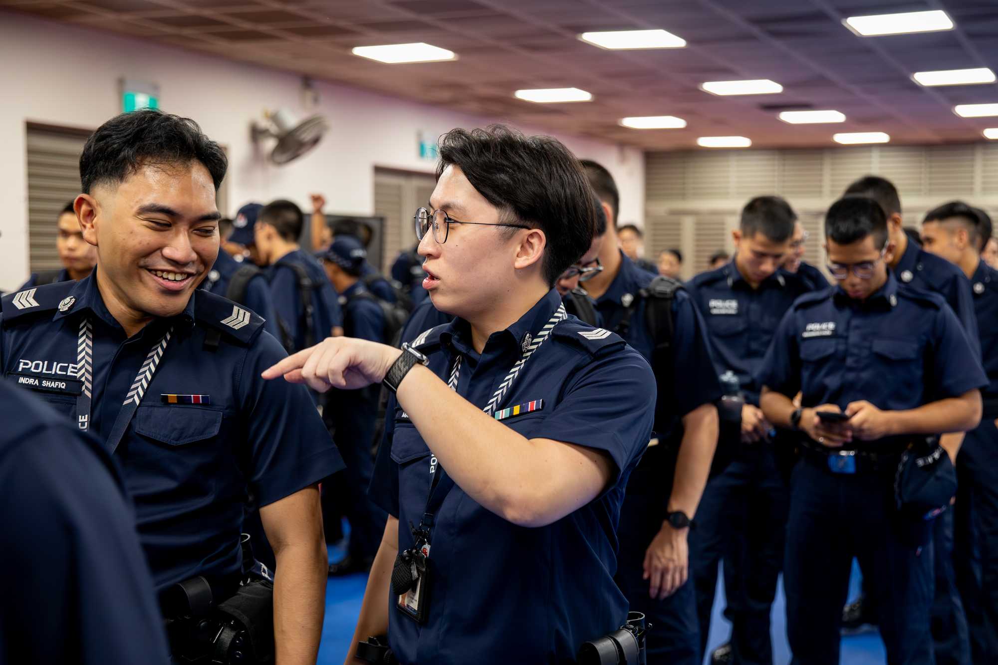 officer in a queue of police officers, talking to a colleague on his right