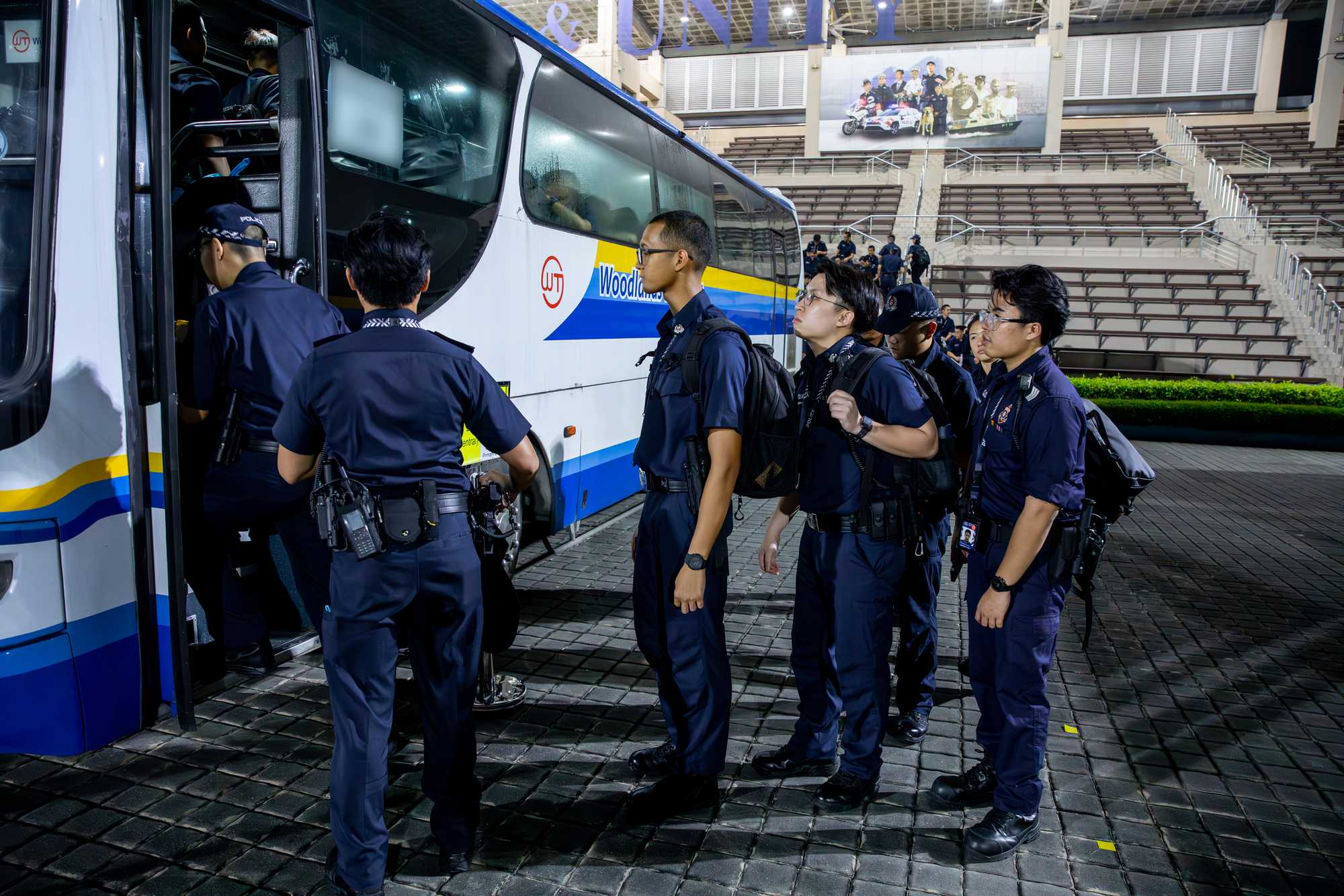 officers queuing and climbing onto a bus