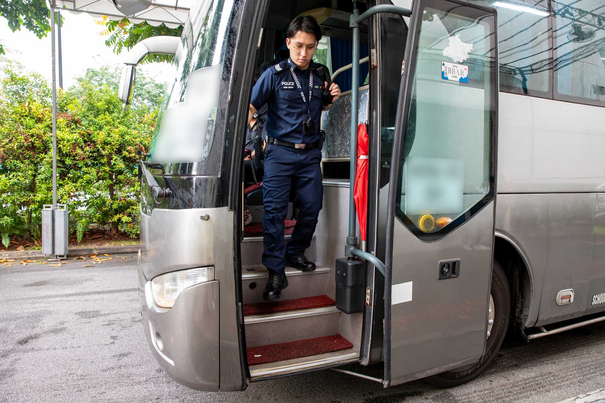 officer alighting from a grey bus