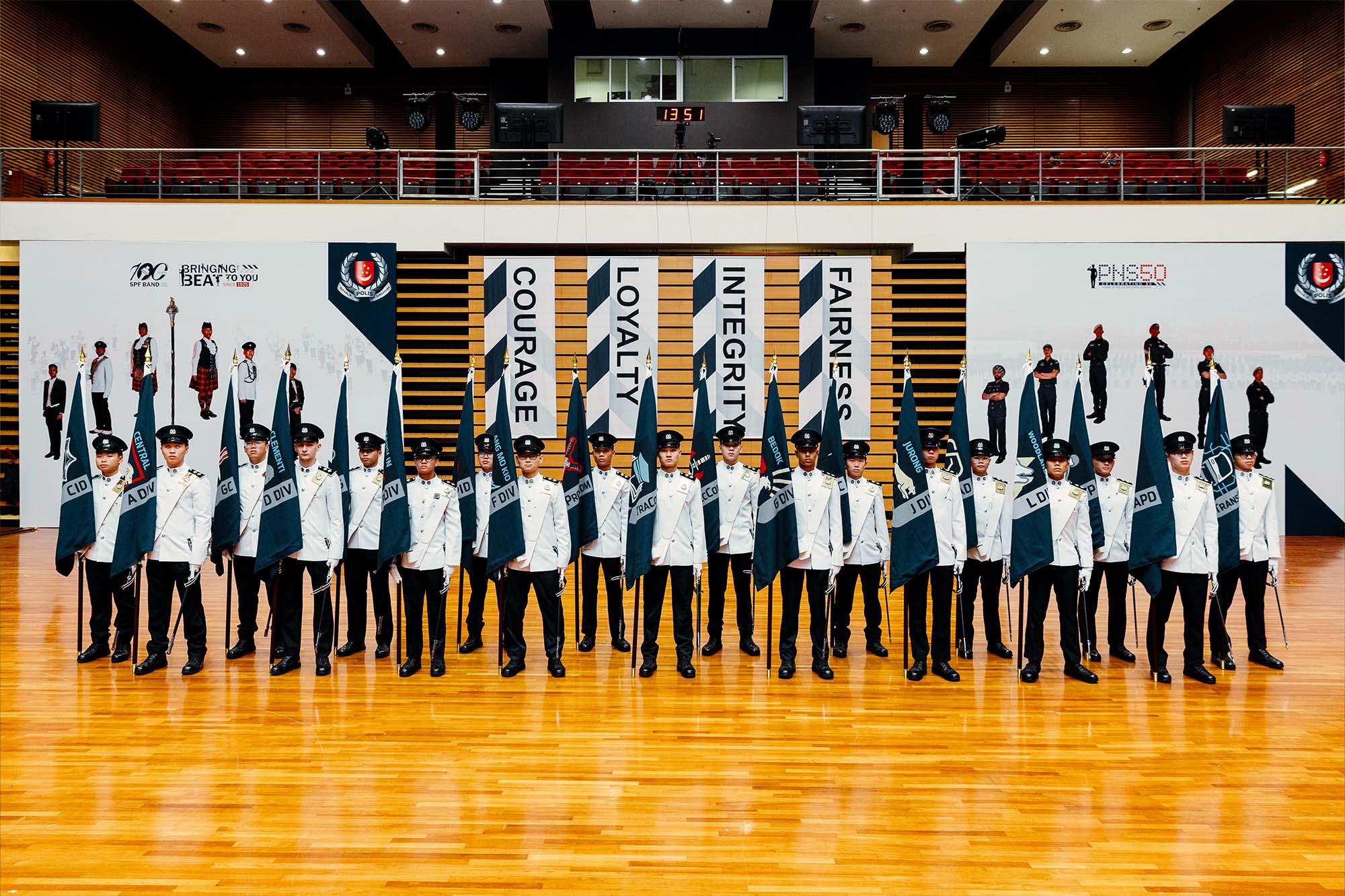 a full row of flagbearers in white no.1 uniform carrying the respective unit flags