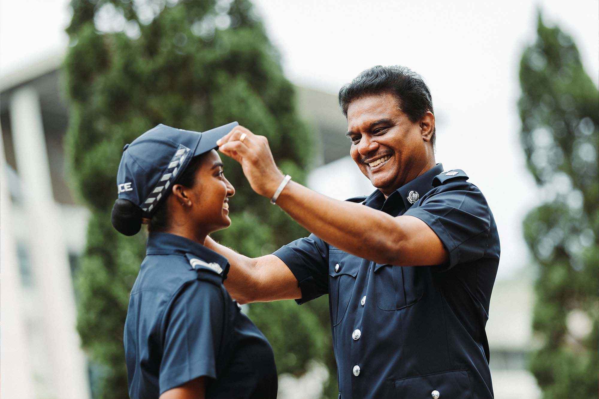 supt gunalan helping to adjust his daughter's peak cap in the photo. He is standing on the right