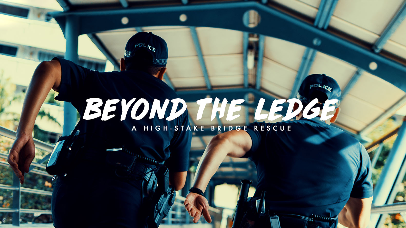 two officers running away from camera on an overhead bridge