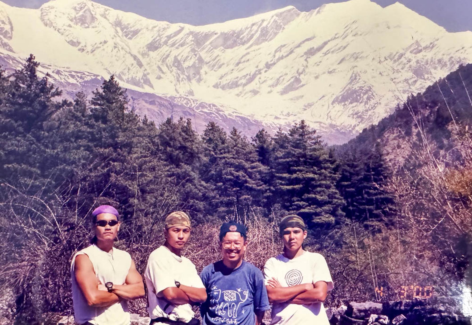 four officers standing with their arms crossed. Behind them there's a huge mountain with a snow top