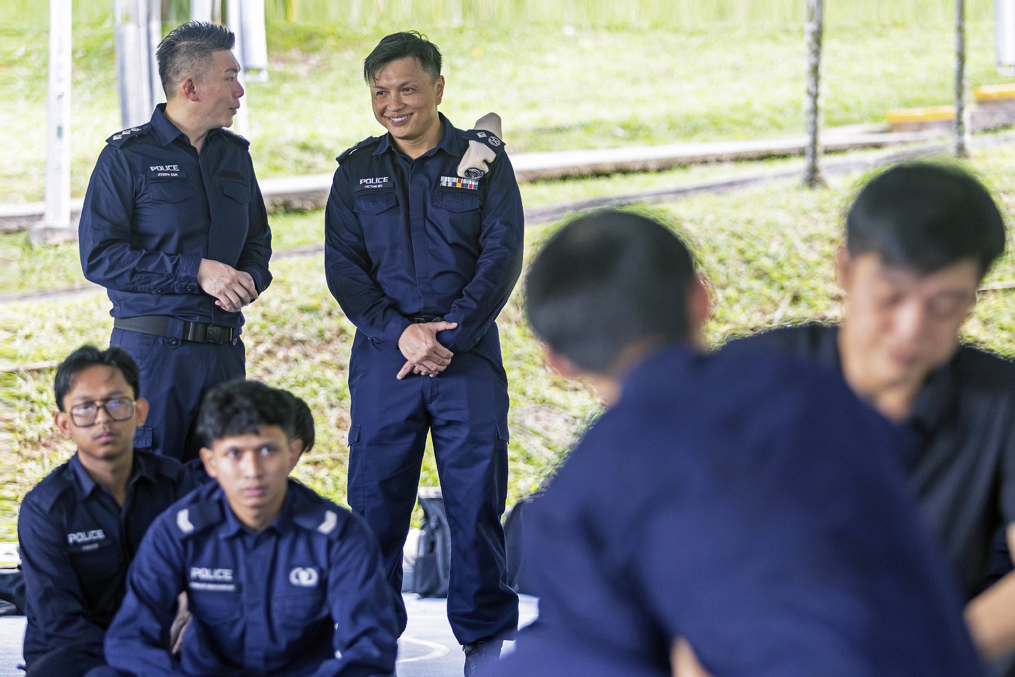 two officers standing and overseeing a police contact tactics demonstration