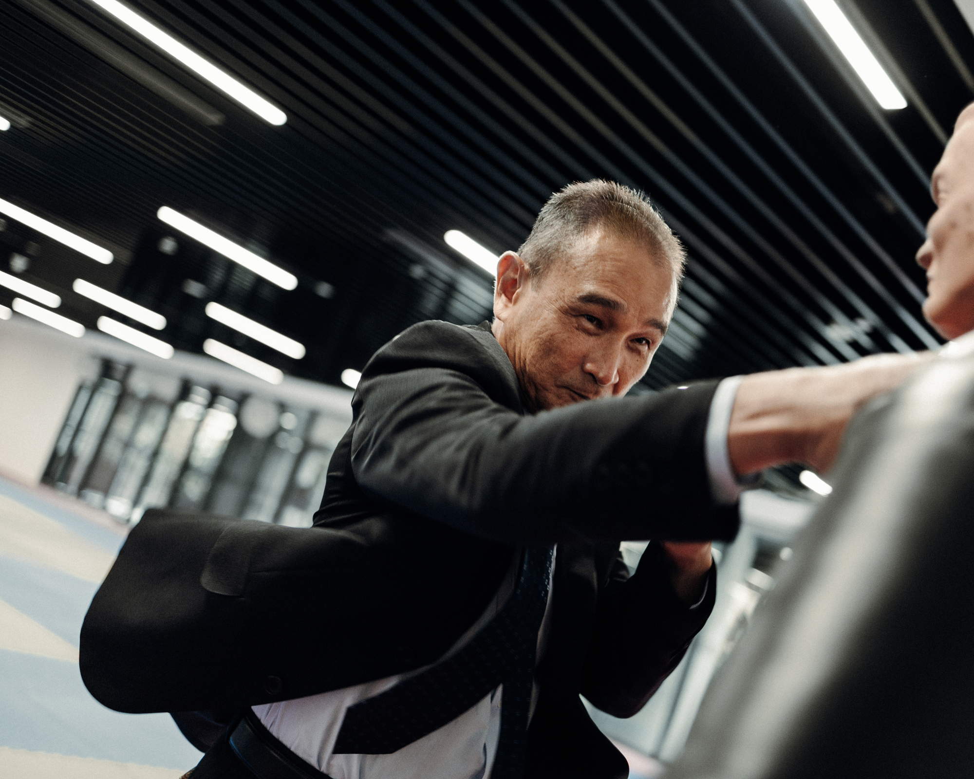 officer in suit and tie punching a punching bag hard