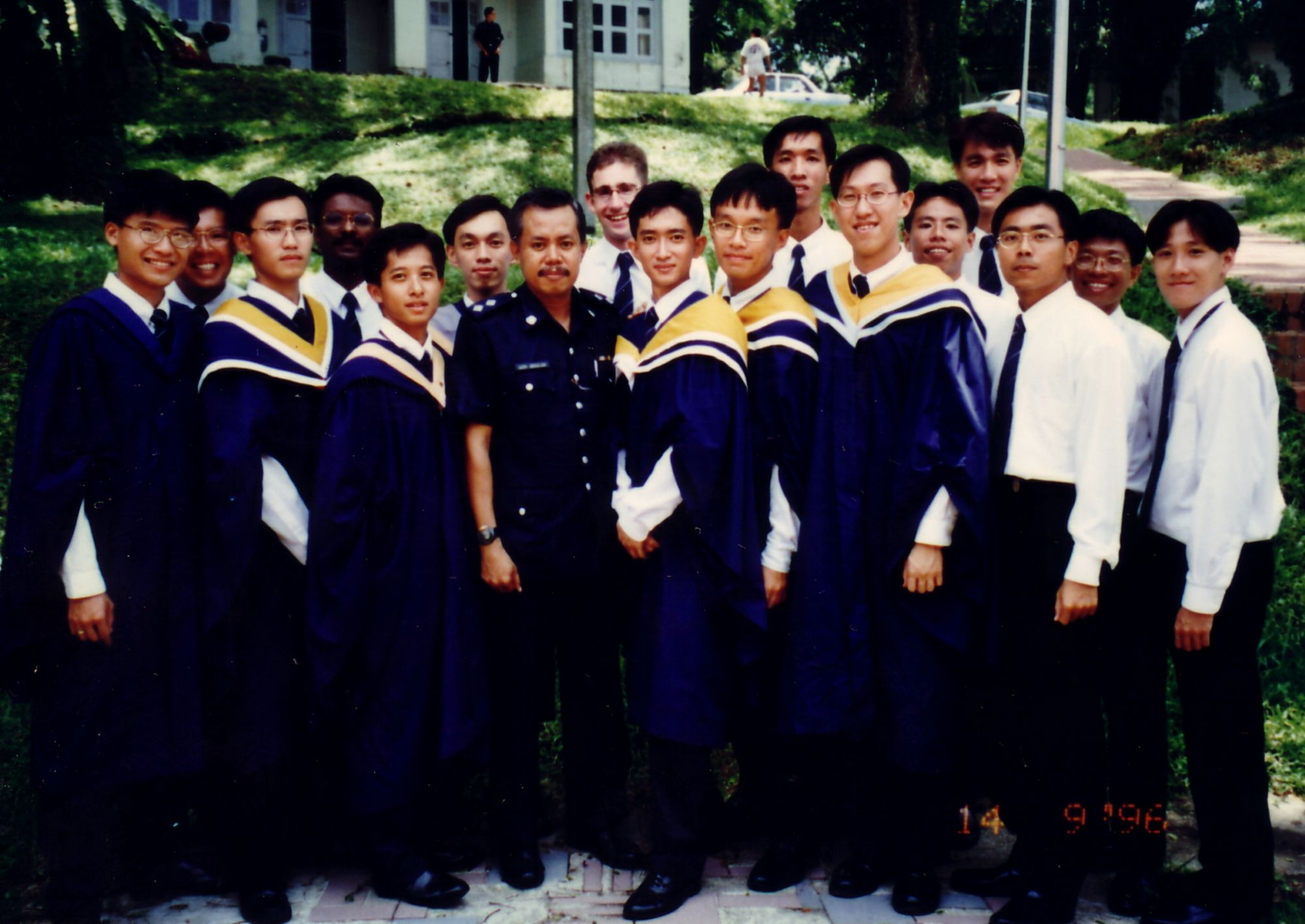 A group photo of police trainees, some in graduation gown, taken at the old police academy.