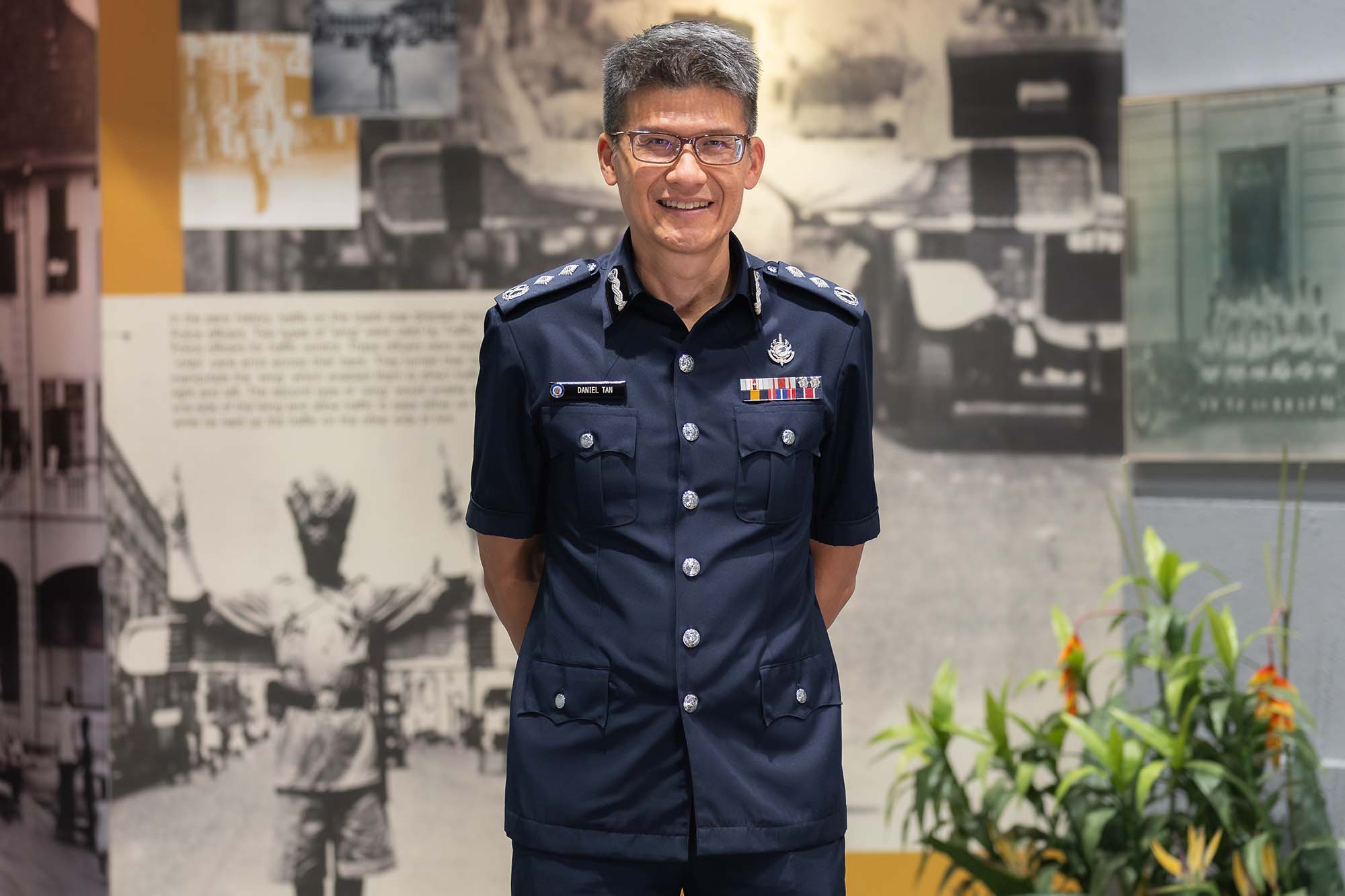 SAC Daniel Tan in a heritage gallery standing with his hands to the back. He is in a police uniform. 