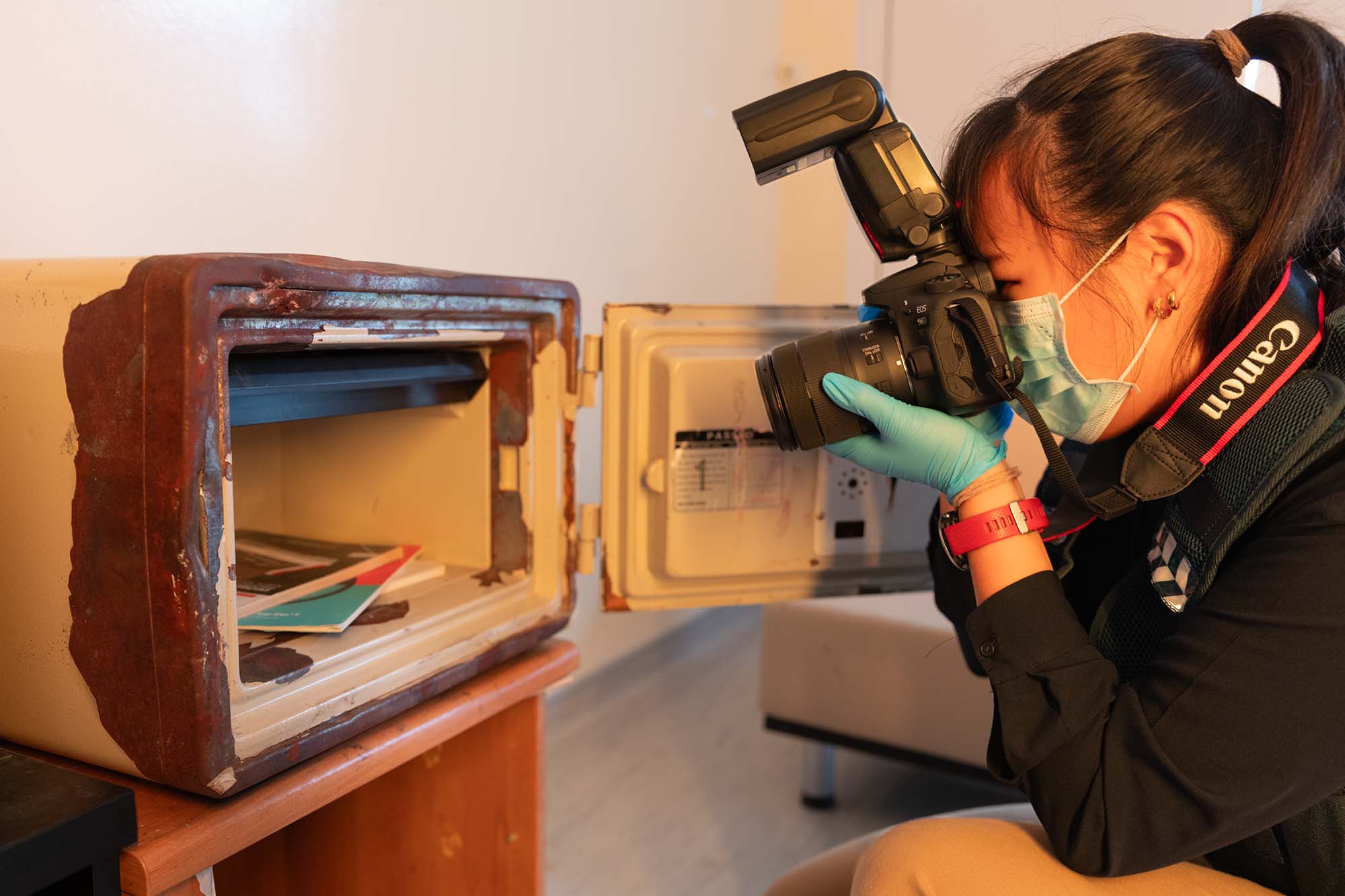Hui Ting photographs items inside a safe. 