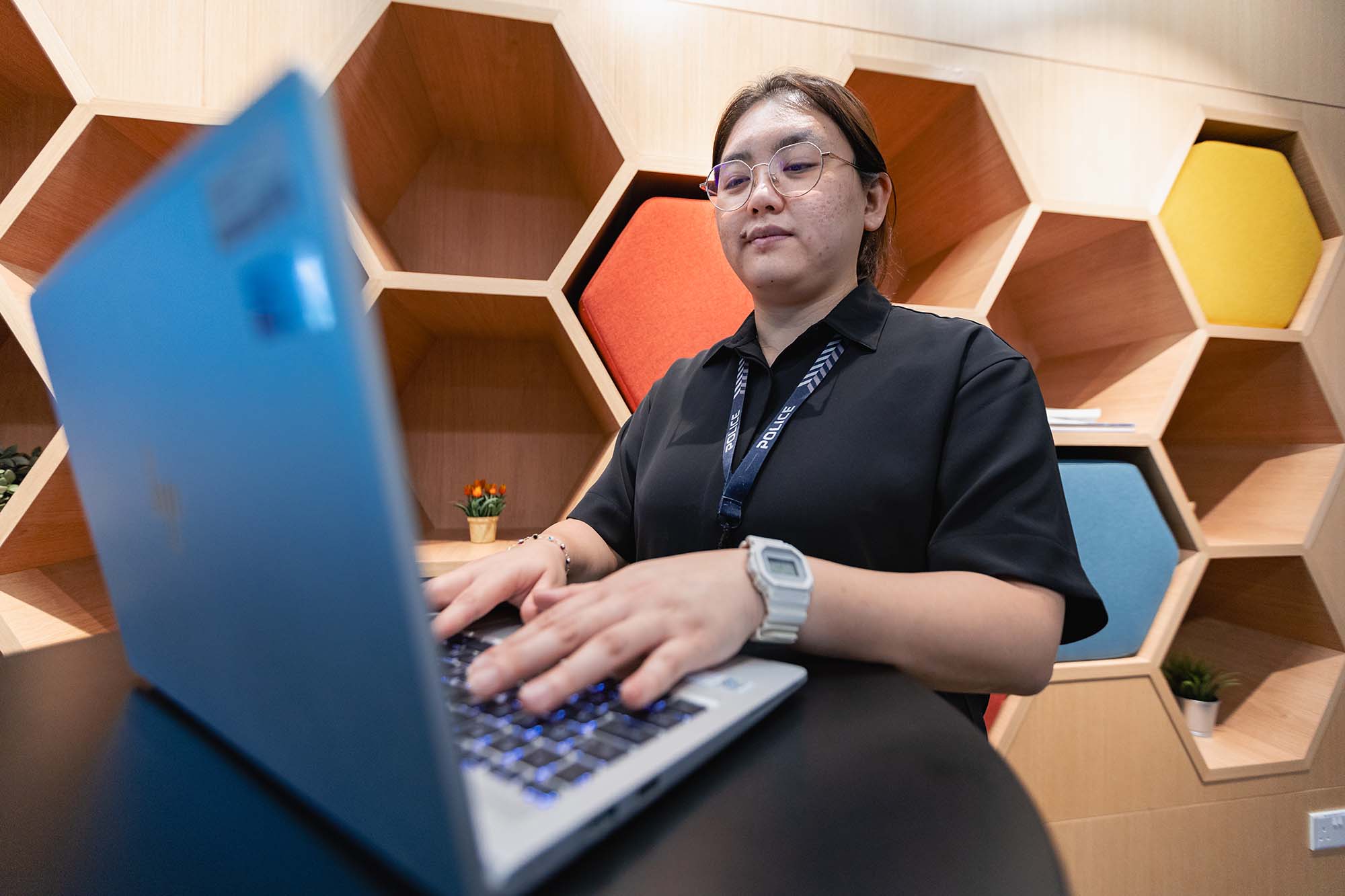 SI Neo working on her laptop.