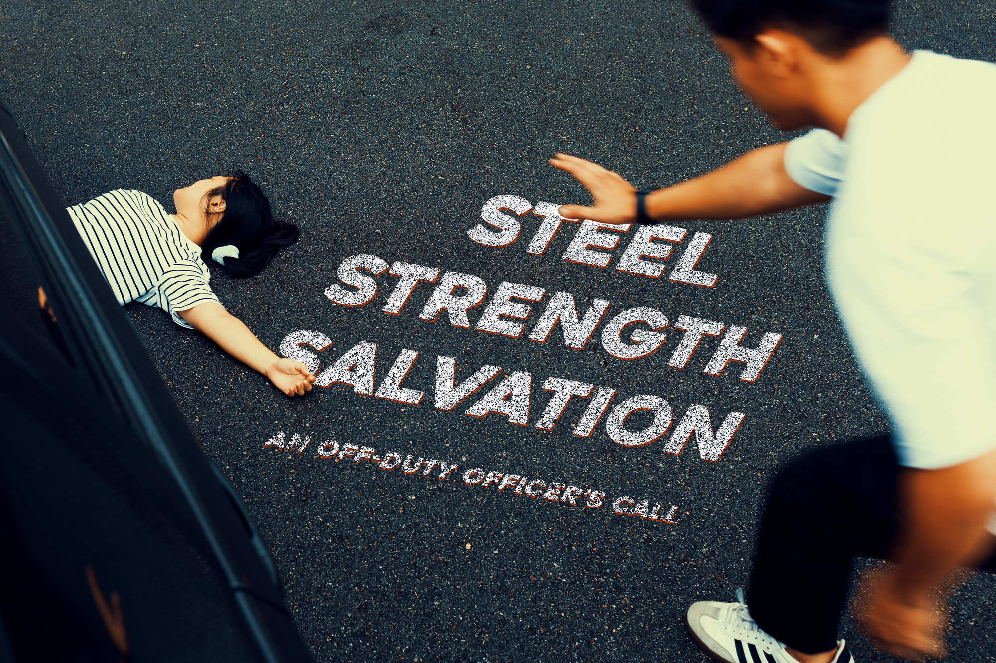 a photo of a teaser image showing a lady lying on the road under a car and a man reaching out to her