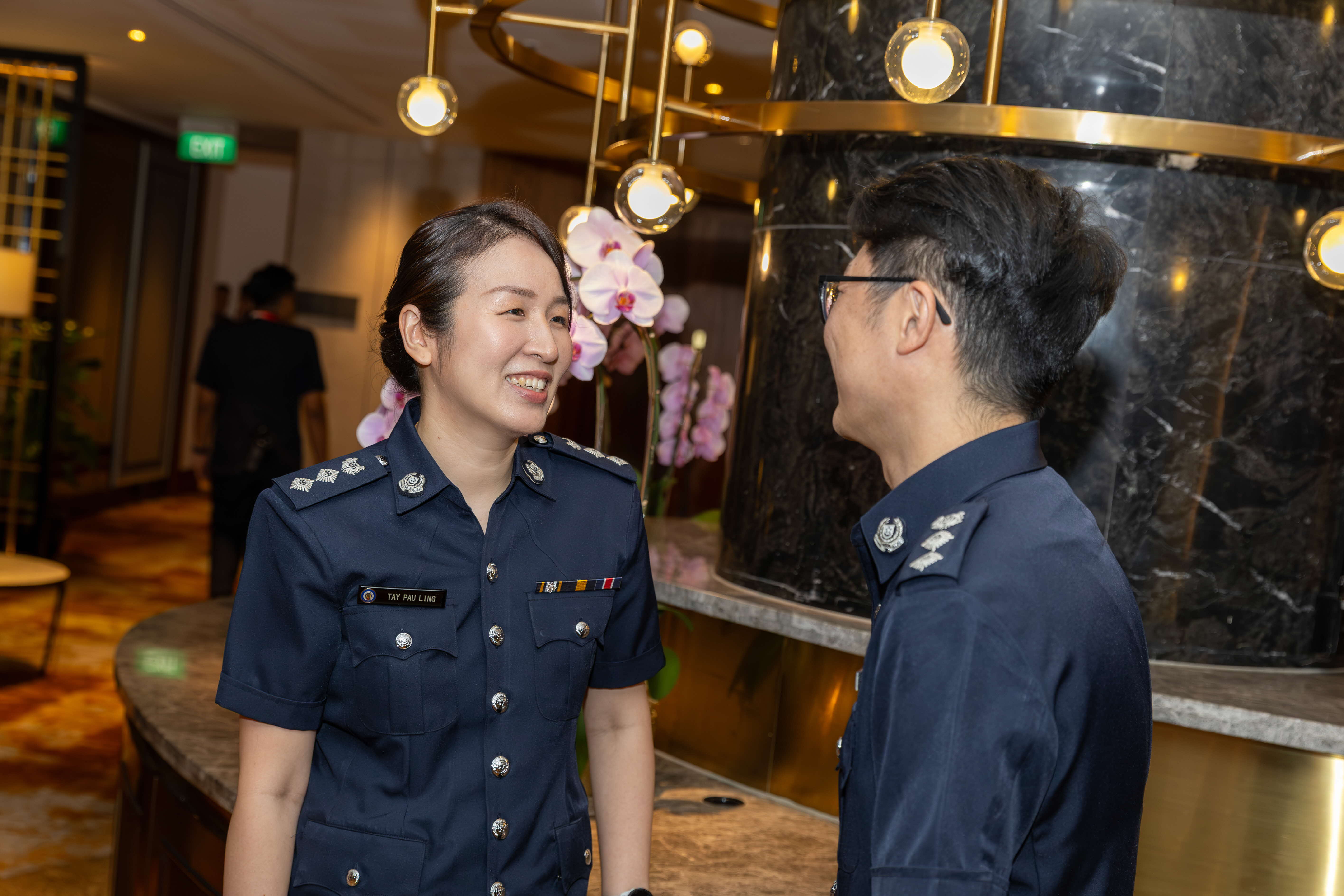 Supt Tay Pau Ling and Supt She Zhao Zuo talking to each other at the Home Team Promotion Ceremony 2026. 