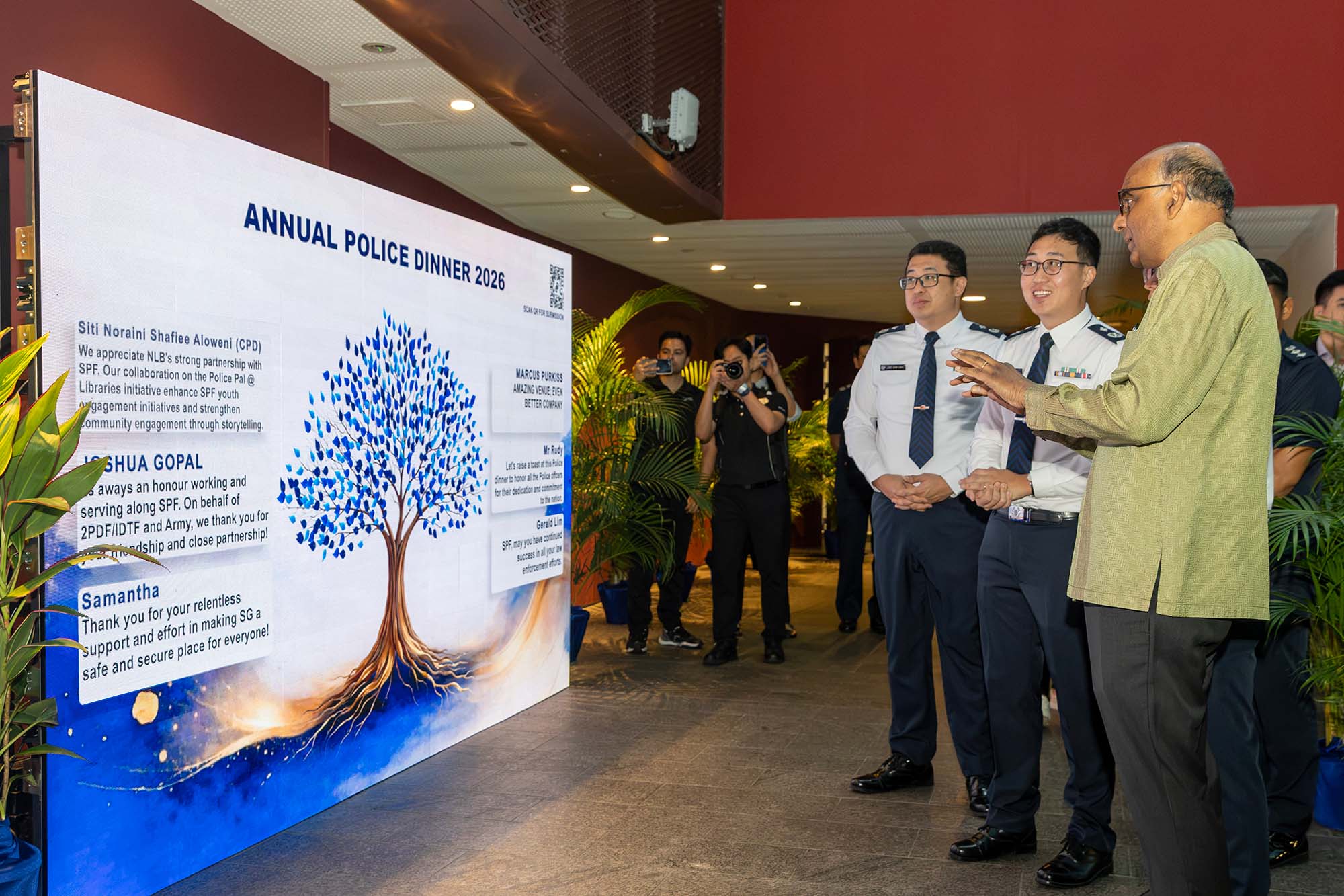 President Tharman looking at the LED wall displaying guests' digital notes of appreciation. 