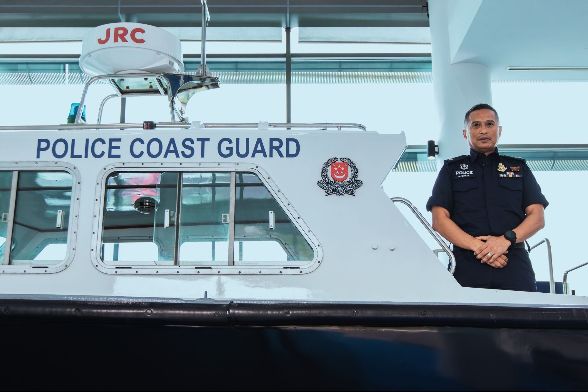 ASP Idzwan posing next to a Police Coast Guard vessel. 