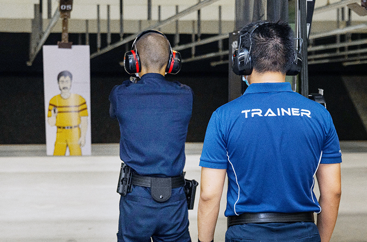 police trainee in the range firing gun for weapon handling training