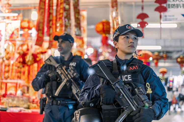 ERT patrolling through Chinatown complex with decorations hanging in background