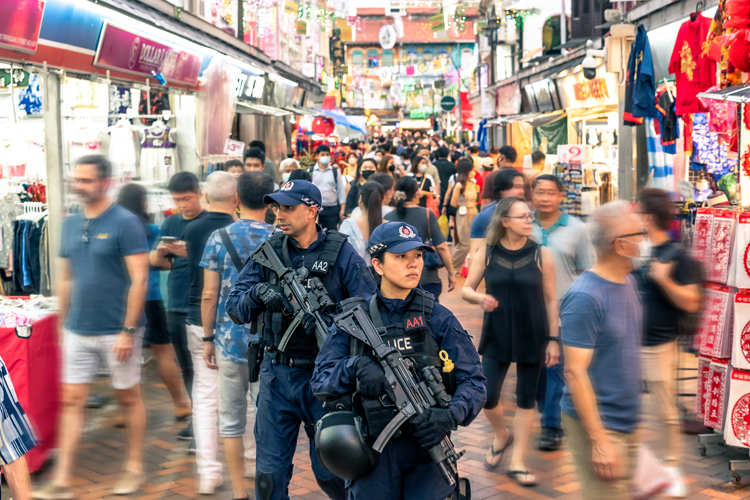 ERT patrolling along temple street, with crowd moving quickly in a motion blur