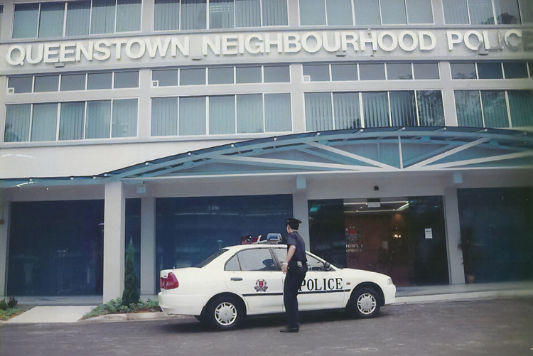 police officer opening car door infront of the old queenstown npc building