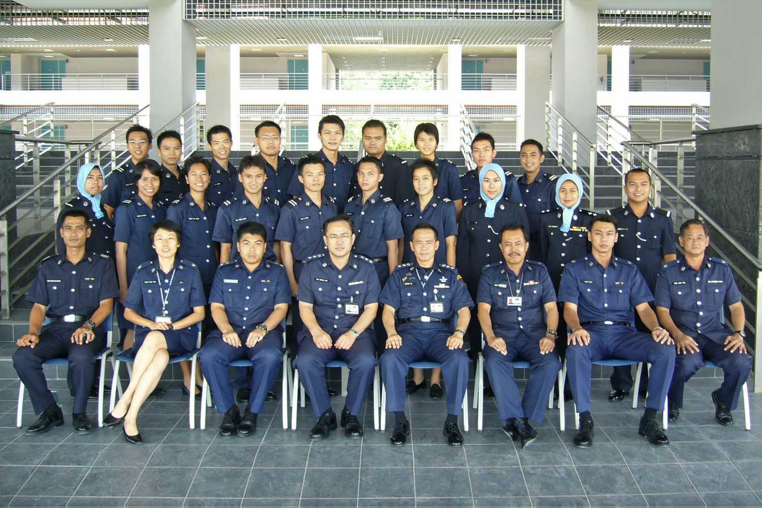 group of uniformed officers taking a squad photo at Home Team Academy