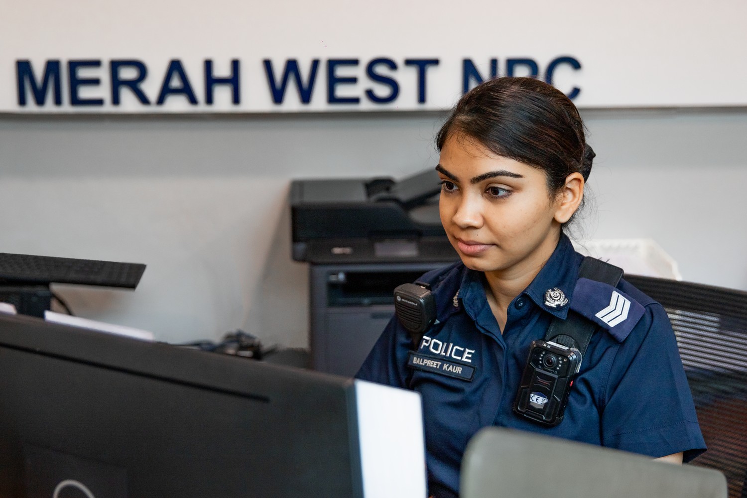 officer sitting at front counter and using the computer