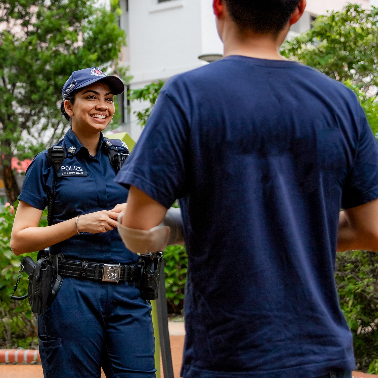 female officer in uniform speaking to a member of public, who is wearing a navy blue t-shirt