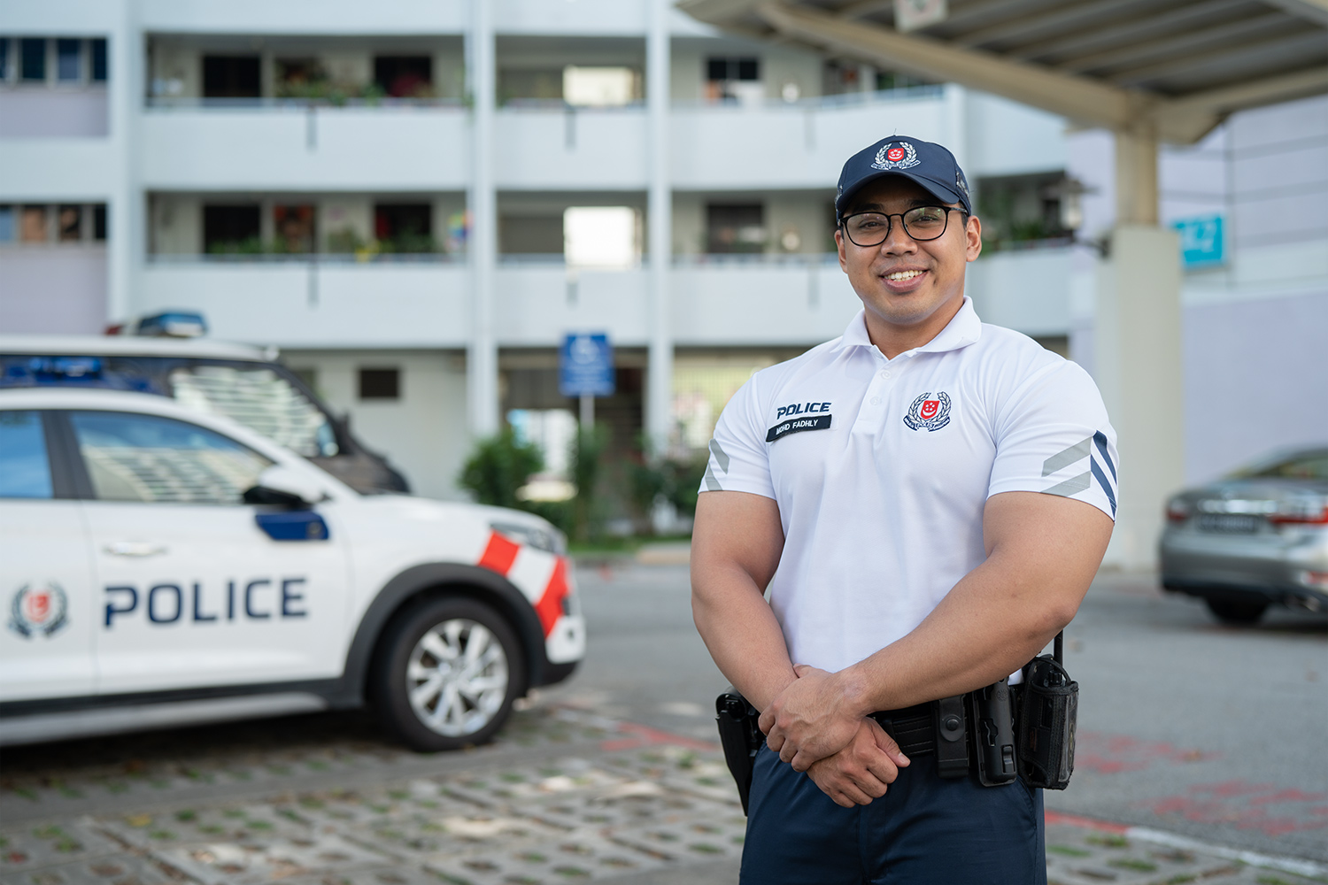 photo of police cpu officer standing in a public carpark infront of a police car